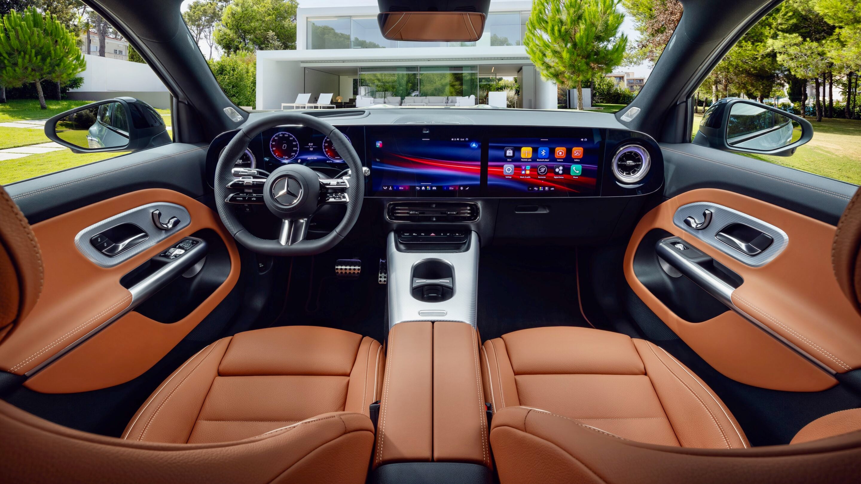 Luxurious car interior with tan leather seats, digital instrument cluster, and wide touchscreen display across the dashboard.