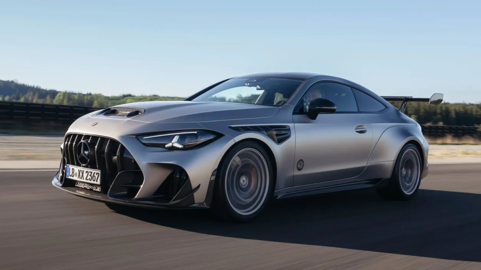 Silver Mercedes-AMG sports car racing on a track, prominent front grille and large rear wing visible.