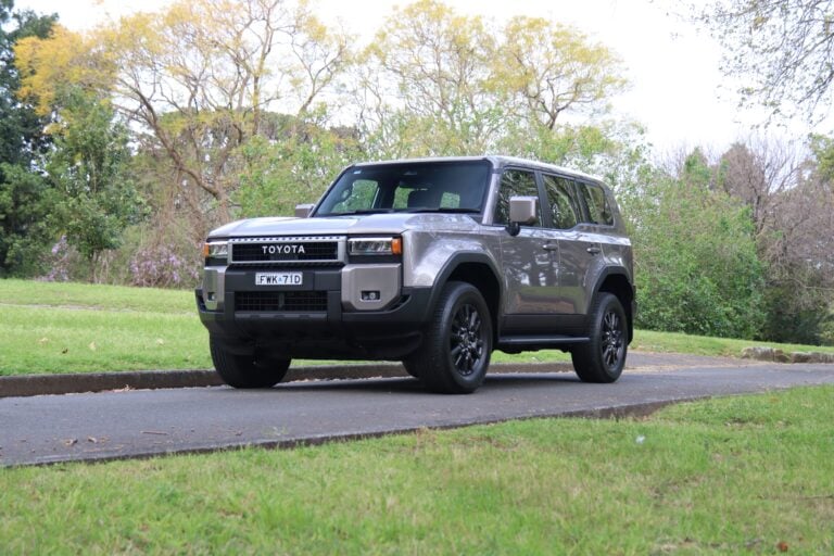 Gray Toyota SUV parked on a curb in a park-like setting with green grass and trees in the background