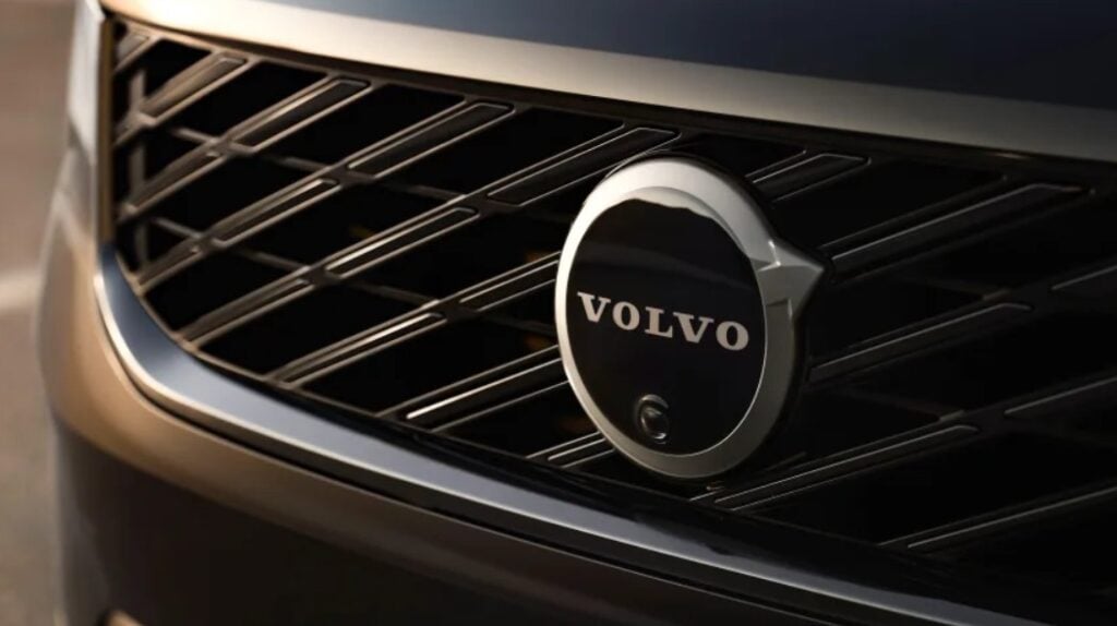 Close-up of a chrome Volvo emblem on the car's front grille, centered.