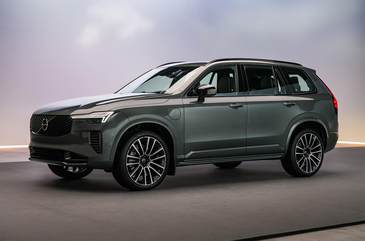 Volvo XC90-style SUV in metallic grey parked in a photography studio, front grille visible.