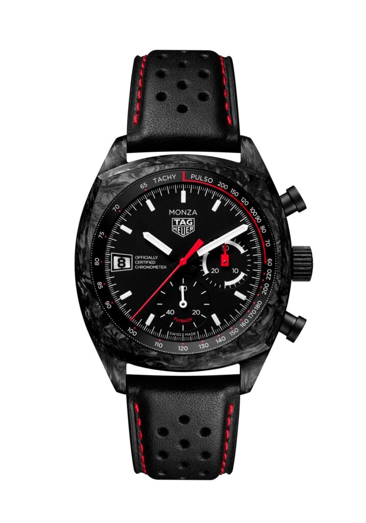 Close-up of a black TAG Heuer Monza chronograph watch with a perforated leather strap featuring red stitching and a tachymeter bezel.