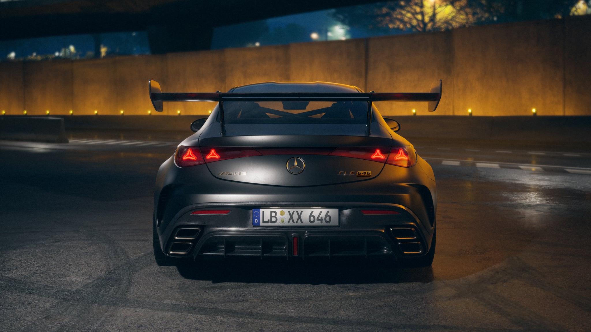 Rear view of a silver Mercedes‑AMG with a large carbon wing in a dimly lit parking area at night.
