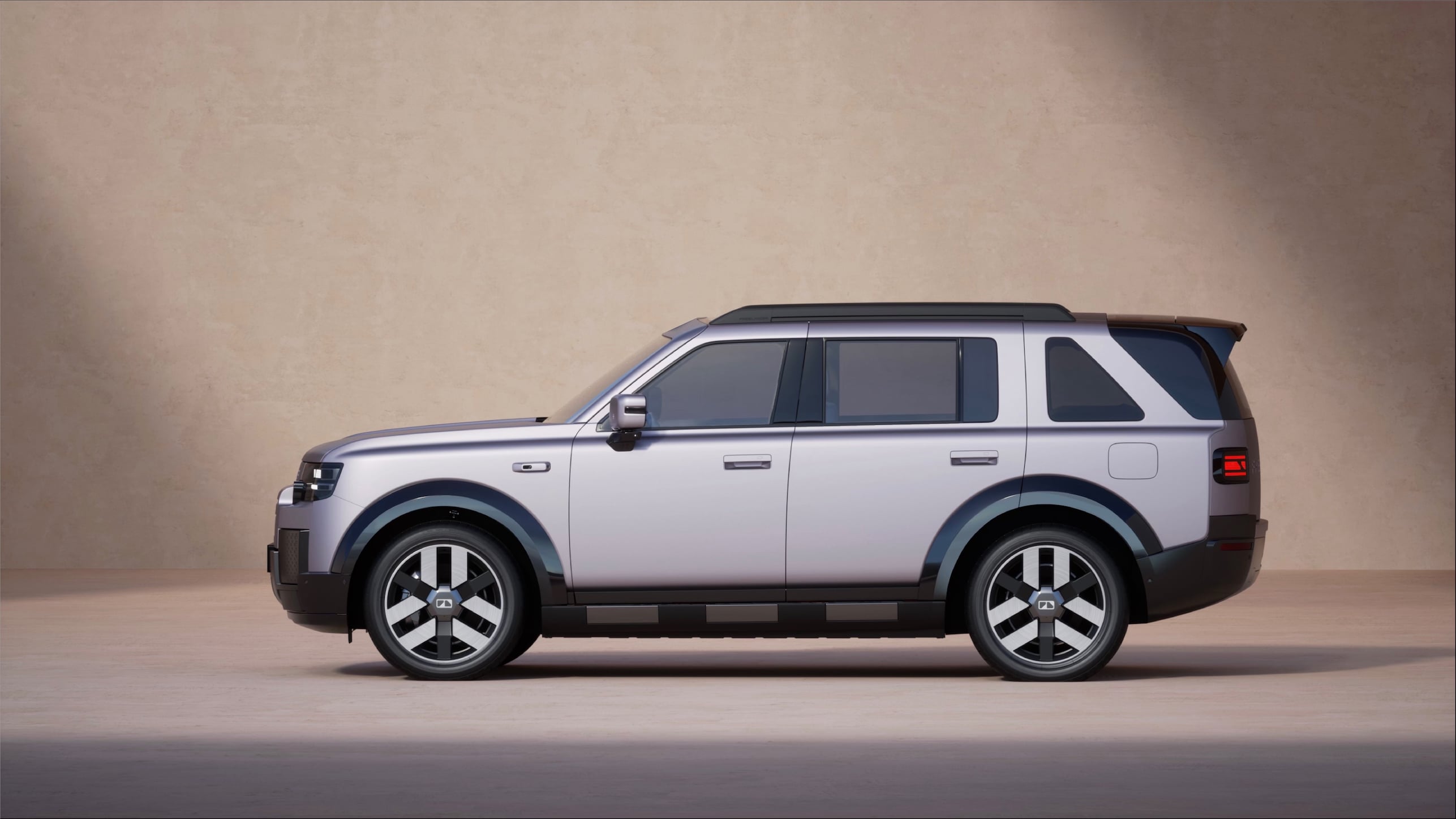 Side view of a silver SUV parked indoors against a beige wall. (informative)
