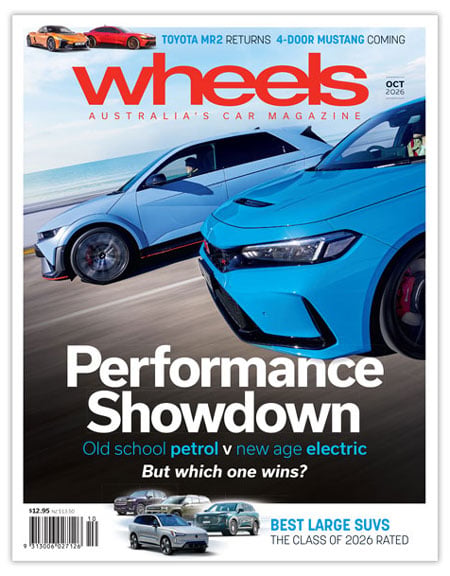 Wheels magazine cover showing two race cars with the headline “Performance Showdown” and the subtitle “Old school petrol vs new age electric.”
