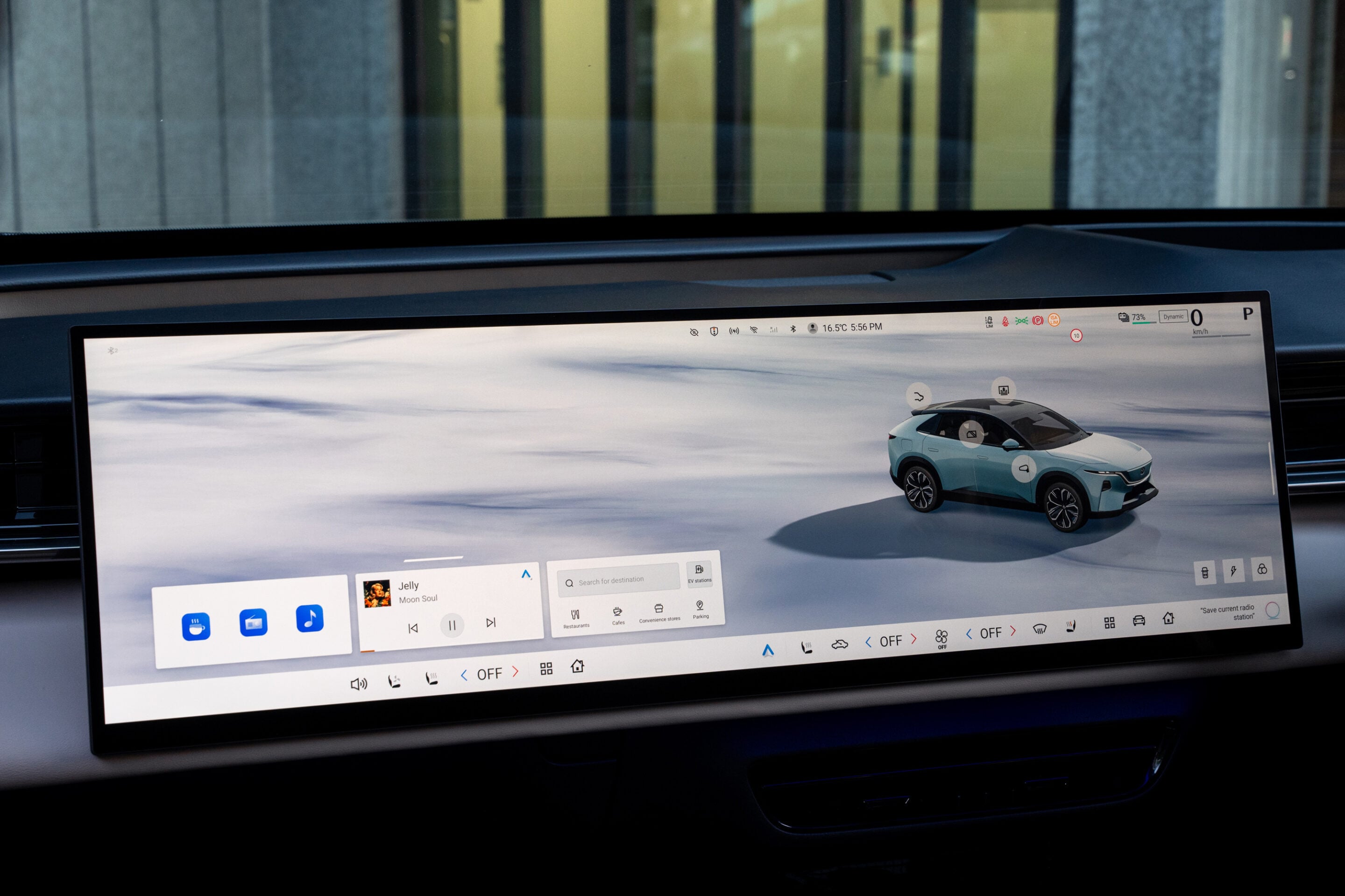 In-car touchscreen displaying a 3D blue SUV model with app icons and vehicle controls