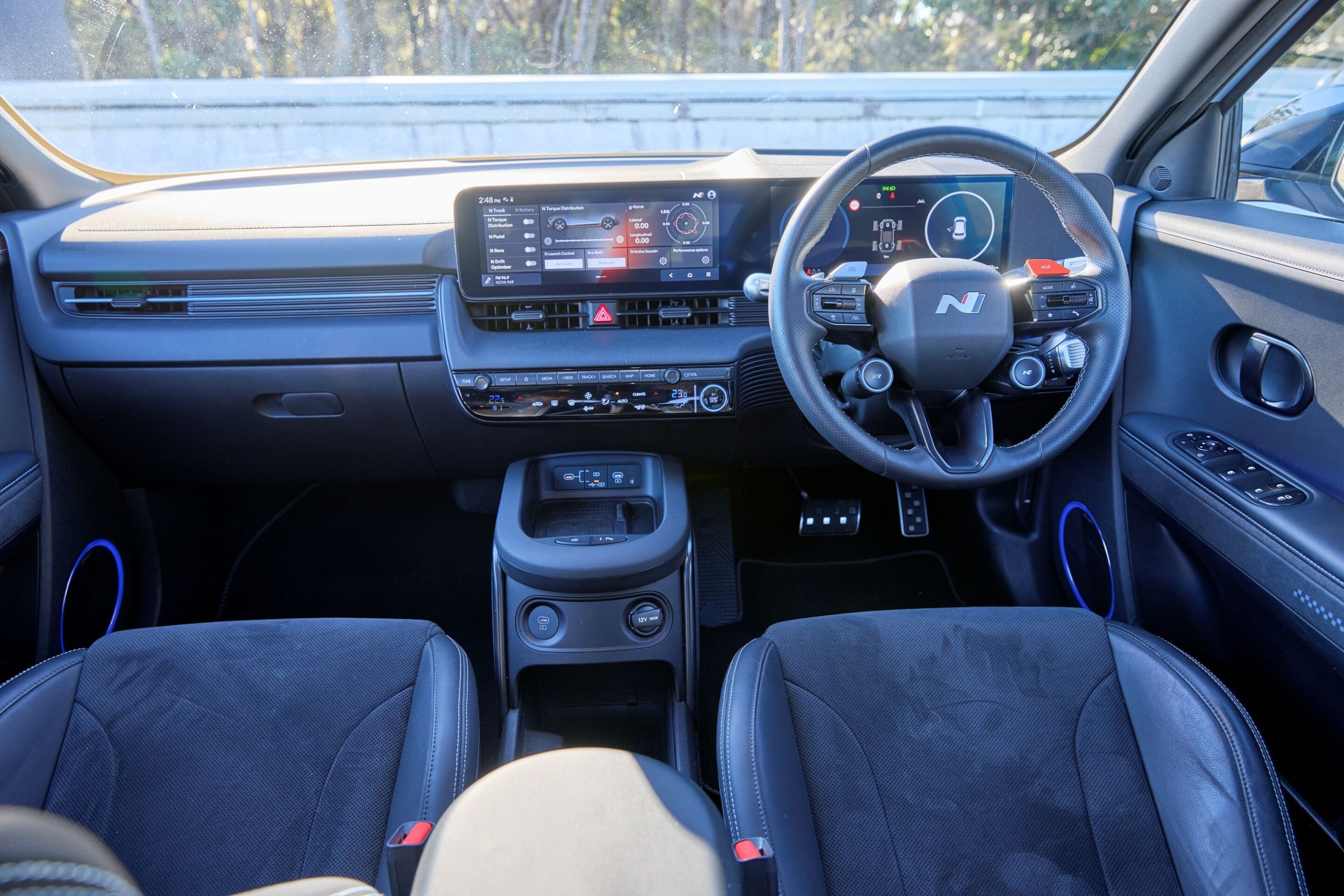 Modern car interior featuring a large center touchscreen, digital instrument cluster, and climate controls.