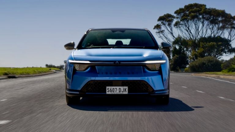 Front view of a blue SUV driving toward the camera on a curved road; license plate S607 DJK (South Australia).