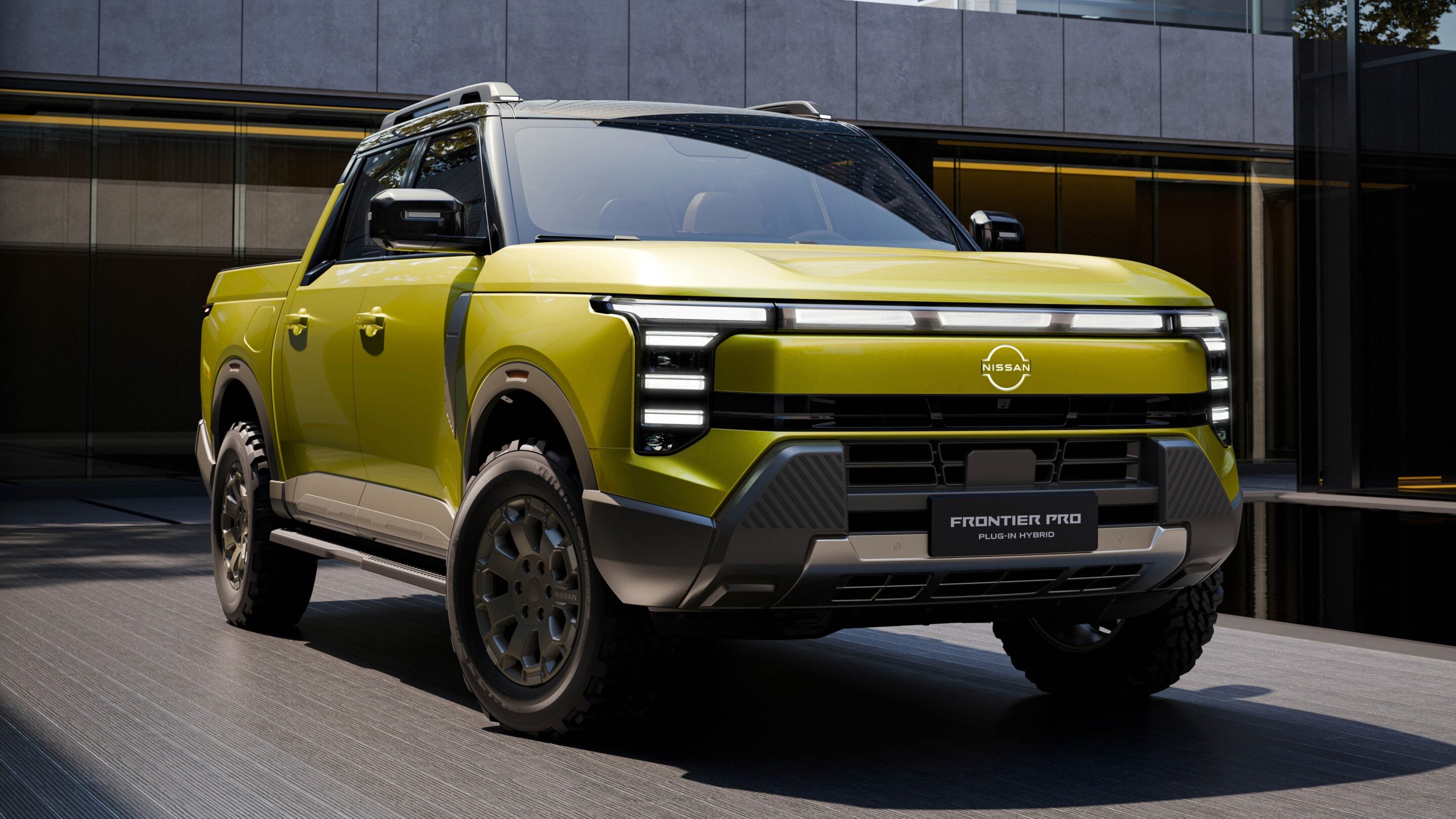 Yellow Nissan Frontier Pro plug-in hybrid pickup truck parked outside a modern glass building.
