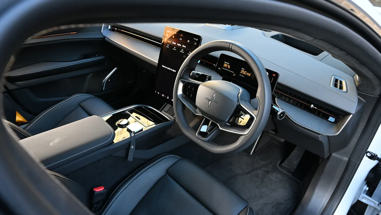Luxurious car cabin with a large vertical touchscreen, digital dashboard, and leather seats awaiting driver interaction.