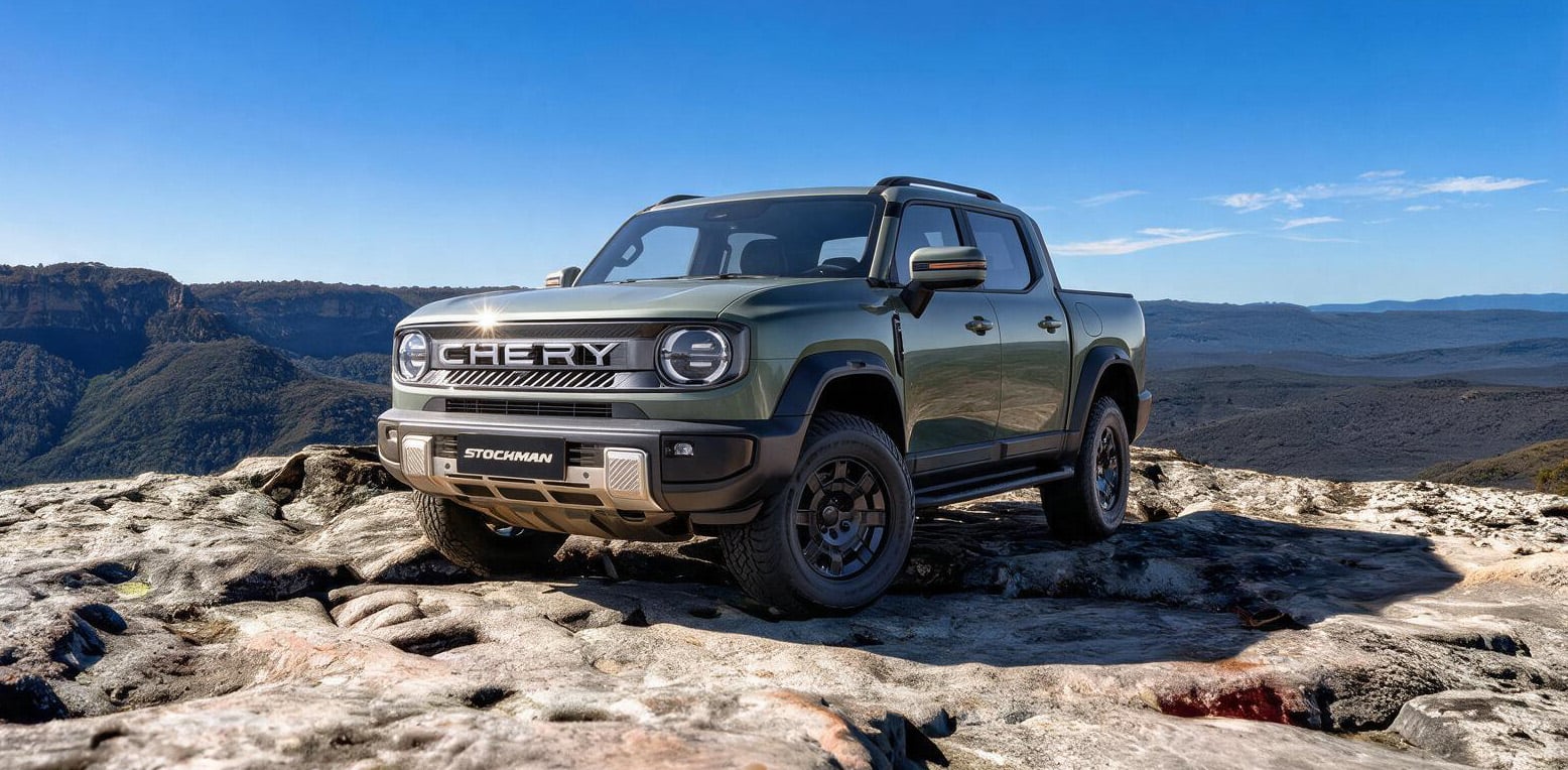 Green CHERY Stockman pickup parked on a rocky cliff with a clear blue sky and distant mountains behind it.
